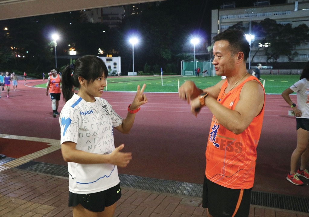 教練姚潔貞（左）會用簡單手語或紙筆，指導亞倫跑步。（陳偉能攝）