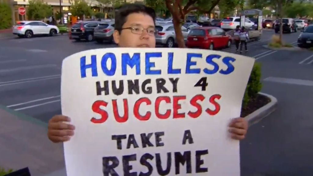 CNN報道，26歲的大學畢業生David Casarez，在山景城（Mountain View）、即Google總部所在地的一條街，舉起「Homeless/Hungry 4 success/Take a resume」的紙牌，向途經的駕駛者及路人派發自己的CV。（圖片來源：影片截圖）