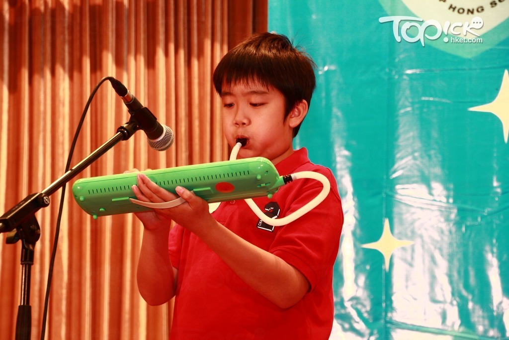 小時候的陳樂男表演吹口風琴。（相片︰受訪者提供）